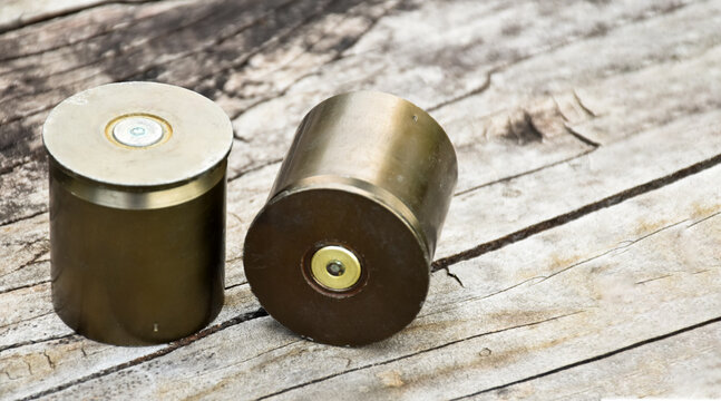 Old and used m203 bullet shells on wooden floor, soft and selective focus.