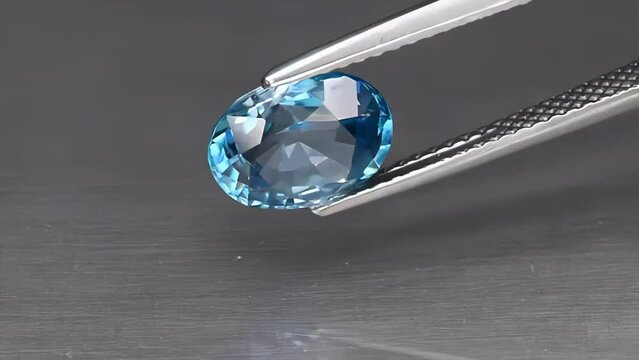 natural gemstone blue zircon oval cut in the tweezers