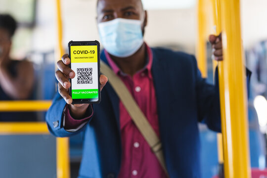 Businessman with covid-19 vaccination certificate on his smartphone screen on the go to office
