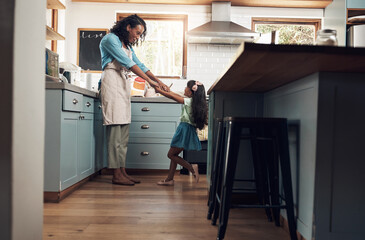 I sustain myself with the love of family. Shot of a young woman dancing with her daughter in the kitchen at home.