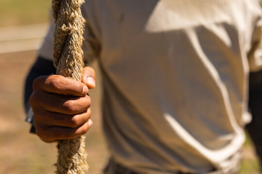 Mid section of male soldier holding rope at boot camp