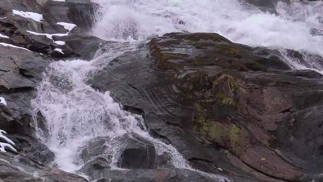 Slow motion waterfall. Water rolls down rock. Looping