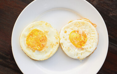 Two fried eggs on a plate in the top view. Protein food. Nourishing meal. Morning breakfast. Cholesterol and diet.