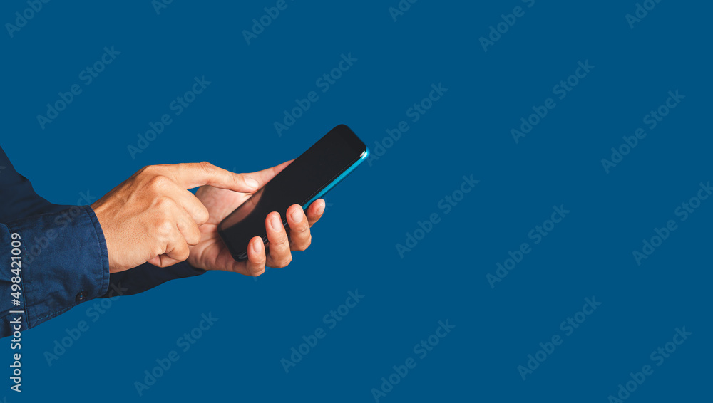 Poster close-up of hands using a mobile phone while standing over a blue background