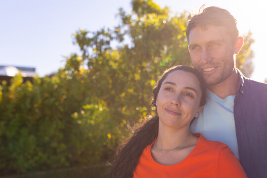 Caucasian couple smiling together standing in the garden on a bright sunny day