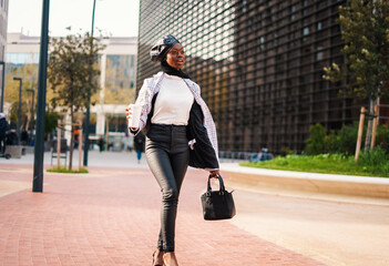 Trendy black woman with takeaway coffee rushing on work