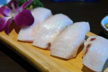 Tuna sushi served on a wooden cutting board.