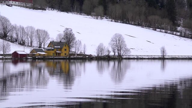 A Norwegian farm reflected in Hornindal Lake, looping. set left.