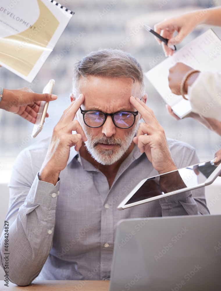 Poster feeling a bit overwhelmed. cropped shot of a handsome mature businessman looking stressed while bein