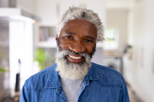 Portrait of smiling african american senior man with white beard and hair at home