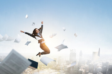 Fototapeta na wymiar Portrait of energetic businesswoman jumping in open air
