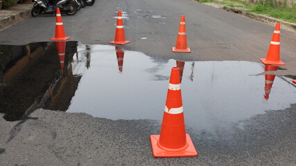 Traffic cones and oil stains. Hydraulic slick on asphalt road surrounded by orange plastic traffic cones. Selective focus