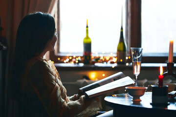 A beautiful woman drinks champagne at the hotel. Relaxes and enjoys life. Vertical photo.