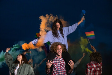 Happy group of people dancing and celebrating LGTB rights want rainbow flag in coloured smoke.