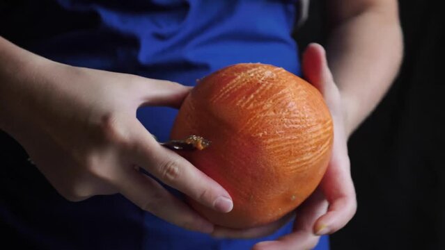 Woman removes grapefruit peel