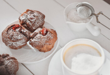 Bright and airy breakfast with berry muffins, big cup of coffee, overhead view
