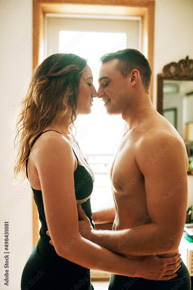 Poster Mornings are for romance. Shot of an affectionate young couple spending a romantic morning together at home.