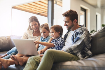 Connected online and as a family. Shot of a mother and father using a laptop with their son and daughter on the sofa at home. - obrazy, fototapety, plakaty