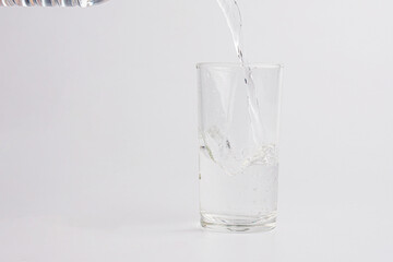 Close up pouring purified fresh drink water from the bottle isolated on white background
