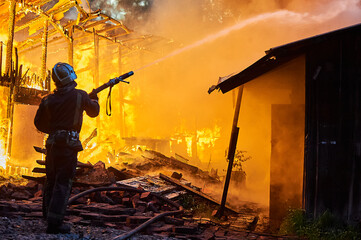 Firefighters extinguish a fire in a farm building