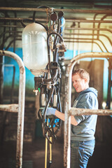 Lets get ready to milk. Shot of a farmer preparing the cow milking equipment on a dairy farm.