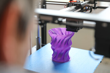 An engineer controls the machine. Layer-by-layer 3D printing of a polymer plastic part. Sample production