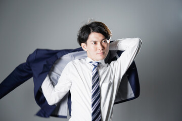 ビジネスマン  ジャケットを着る　グレー背景