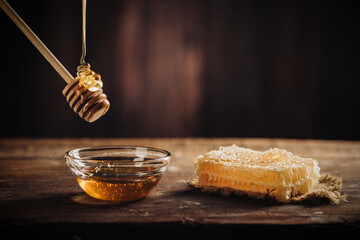 Homemade honey with honeycomb on a rustic wooden table - 498439469