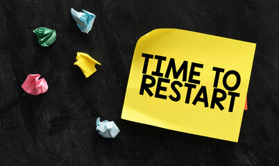 TIME TO RESTART words on a yellow sheet of paper and a black background.