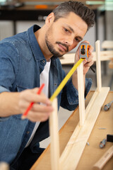 man is measuring wood flooring