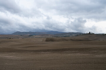 Fototapeta na wymiar View on hills of Tuscany, Italy. Tuscan landscape with ploughed fields in autumn.