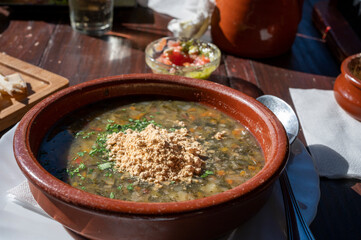 Dinner at guachinche, typical Canary Island establishment on Tenerife, where locally produced white or red wine served accompanied by homemade traditional food, vegetable soup with gofio