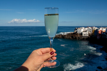 New year celebration with glass of champagne or Spanish cava sparkling wine and view on blue Atlantic ocean, Canary islands, winter tourists destination