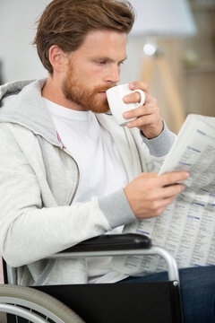 happy man at home drinking coffee and reading newspaper