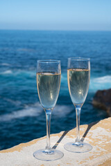 New year celebration with two glasses of champagne or Spanish cava sparkling wine and view on blue Atlantic ocean, Canary islands, winter tourists destination