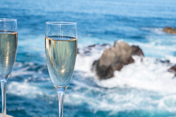 New year celebration with two glasses of champagne or Spanish cava sparkling wine and view on blue Atlantic ocean, Canary islands, winter tourists destination
