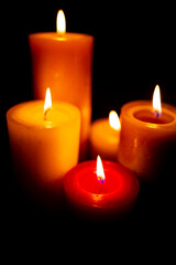 Burning red candles on black background