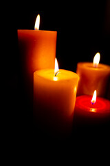 Burning red candles on black background