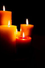 Burning red candles on black background