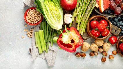 Delicious raw fruits and vegetables on light background.
