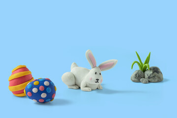 Cunning bunny and easter eggs handmade from plasticine on blue background
