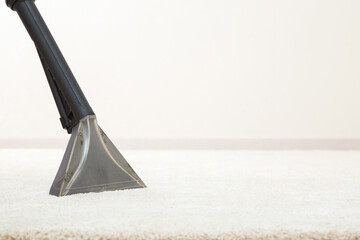 Big spray nozzle of professional vacuum cleaner washing white carpet at home. Closeup. Commercial...