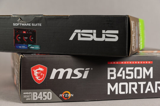 MSI B450 MORTAL MAX motherboard and ASUS GFORCE GTX 1650 graphics card against gray background. Boxs with the new computer hardware. Modern computer components.