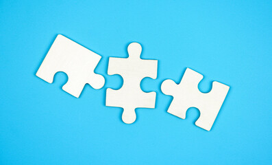 Top view three piece of white jigsaw puzzle isolated on a blue background. 