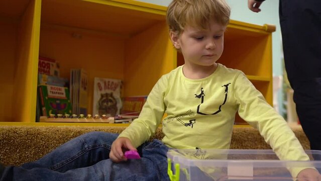  Handsome boy playing with kinetic sand in the children's room