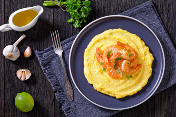 polenta with fried shrimps on plate, top view