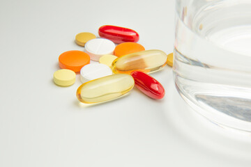 The pills are on the table next to a glass of water. Medicine and healthcare.