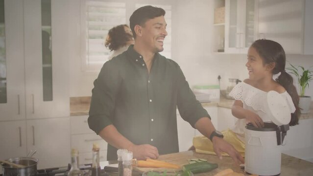 Animation of lights over happy hispanic father and daughter clapping hands in in kitchen