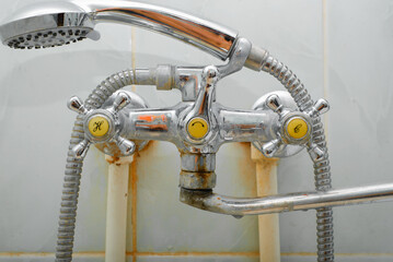 Close-up of a rusty shower faucet, leaking old steel plumbing in the bathroom with plaque