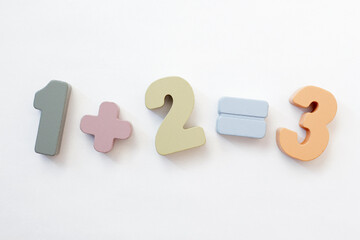 education concept - wooden numbers one plus two equal three